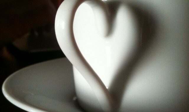 Kaffeetasse bildet ein Herz mit dem Schatten